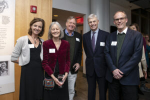 Five adults at a cocktail party smiling at the camera