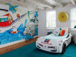 A young boys bedroom with a racing car shaped bed and painted wall