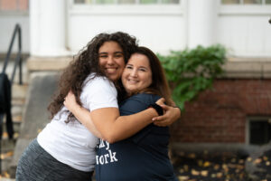 A female college student hugging her female mentor