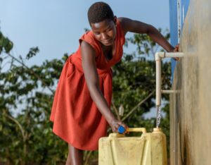 Woman retrieving water from pump